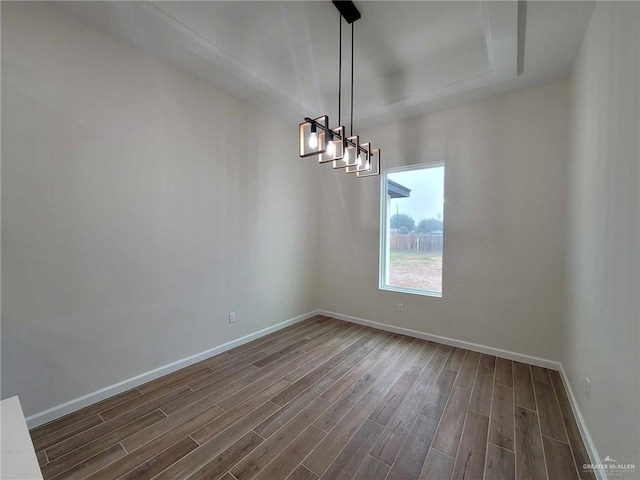 unfurnished room featuring dark hardwood / wood-style floors and a tray ceiling