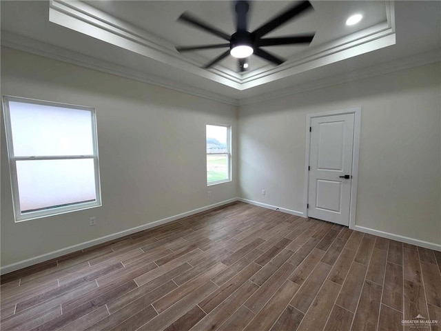 spare room with hardwood / wood-style flooring, ceiling fan, a raised ceiling, and ornamental molding