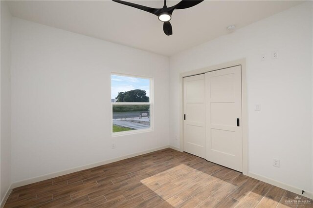 9218 N 25th Ln, Mcallen, TX 78504 - unfurnished bedroom with wood finished floors, baseboards, a closet, and ceiling fan