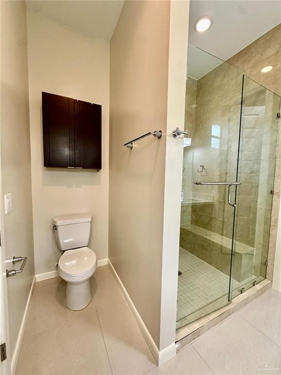 bathroom featuring tile patterned flooring, an enclosed shower, and toilet