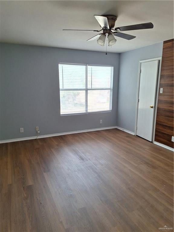 empty room with dark hardwood / wood-style floors and ceiling fan