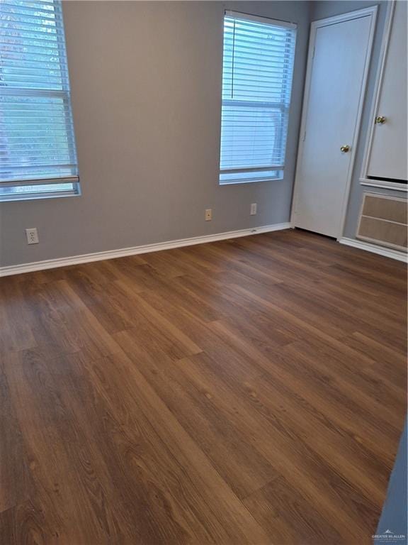 spare room featuring dark wood-type flooring