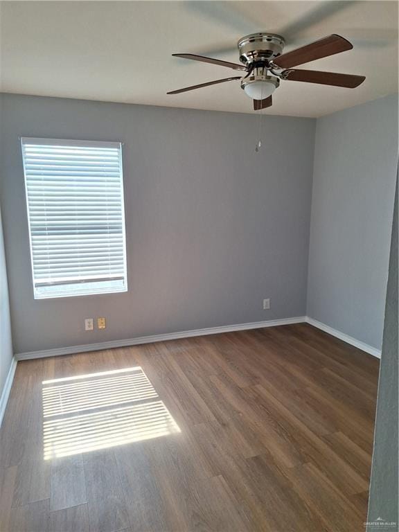 spare room featuring ceiling fan, a healthy amount of sunlight, and wood-type flooring