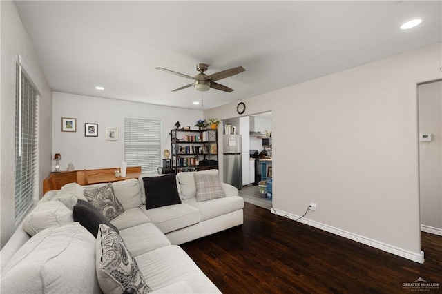 living room featuring dark wood-type flooring and ceiling fan