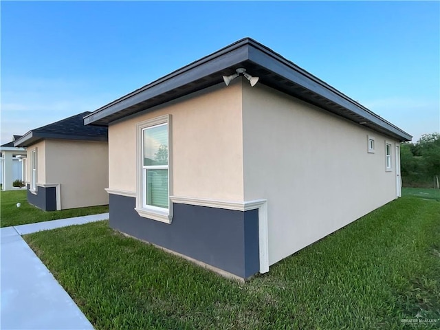 view of property exterior with a lawn and stucco siding