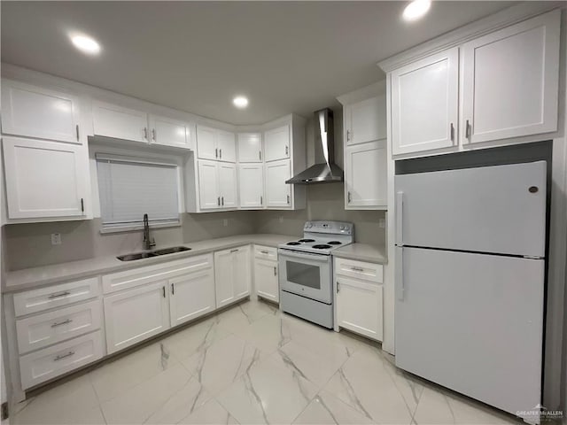 kitchen with white cabinets, a sink, wall chimney exhaust hood, white appliances, and marble finish floor
