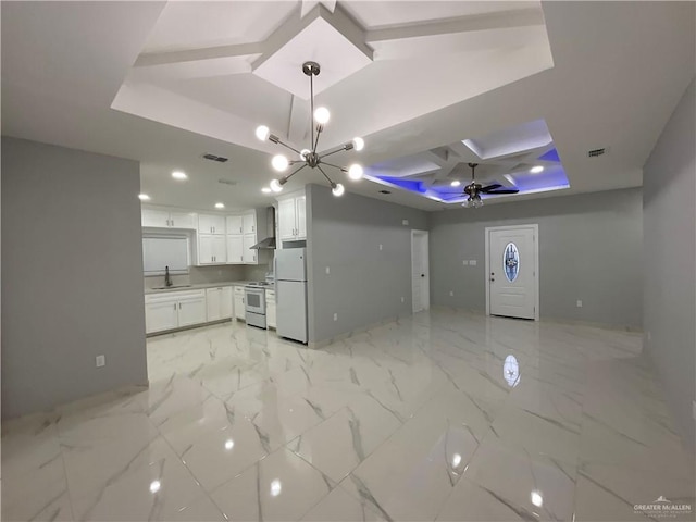 kitchen with a sink, coffered ceiling, wall chimney exhaust hood, visible vents, and white appliances