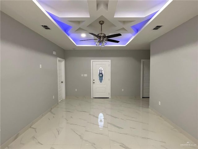 entryway with coffered ceiling, a ceiling fan, visible vents, and baseboards