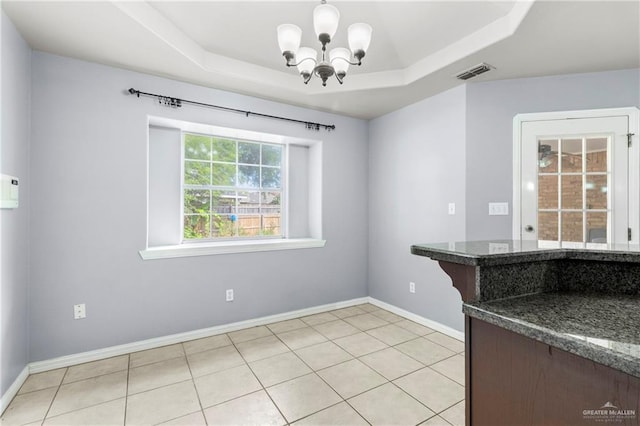 1411 Dons Dr, Mission, TX 78572 - unfurnished dining area with a chandelier, a tray ceiling, baseboards, and light tile patterned floors