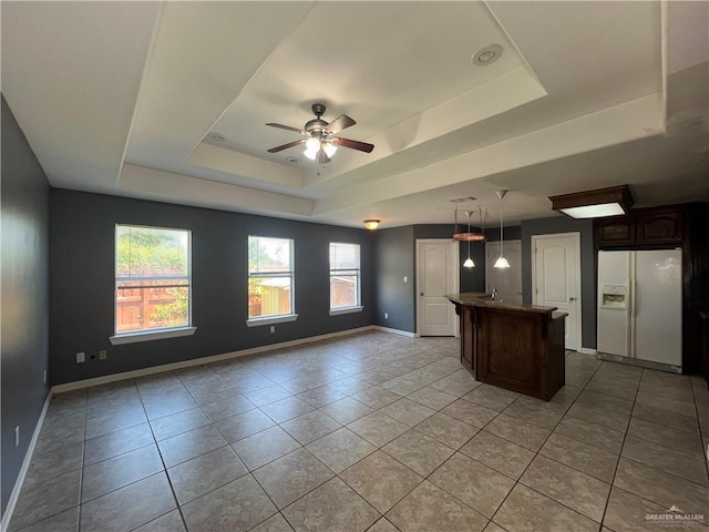 2700 Duke Ave, Mcallen, TX 78504 - kitchen featuring white fridge with ice dispenser, a raised ceiling, healthy amount of natural light, and light tile patterned floors