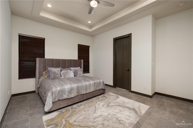 bedroom featuring recessed lighting, baseboards, ceiling fan, and a tray ceiling