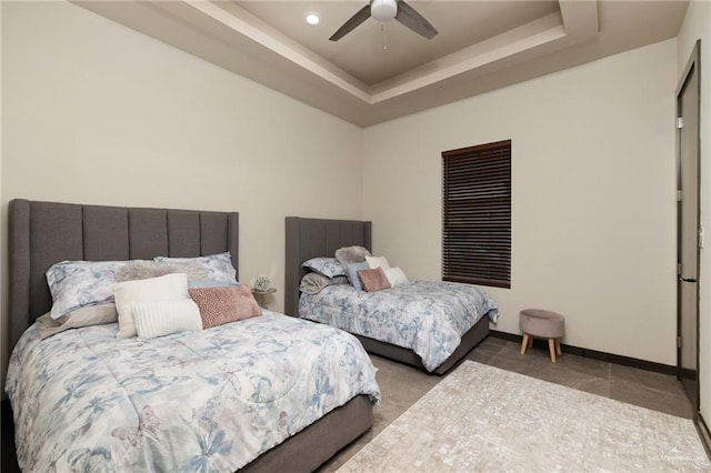 bedroom with a tray ceiling and ceiling fan