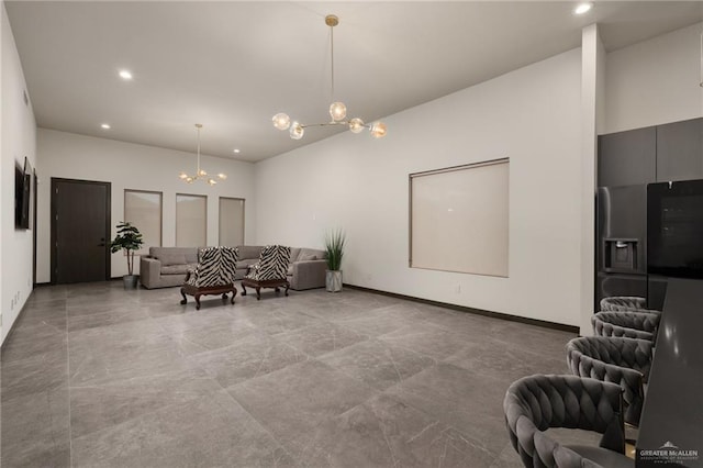 living area featuring baseboards, a chandelier, and recessed lighting