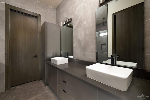bathroom with a sink, double vanity, and tile walls