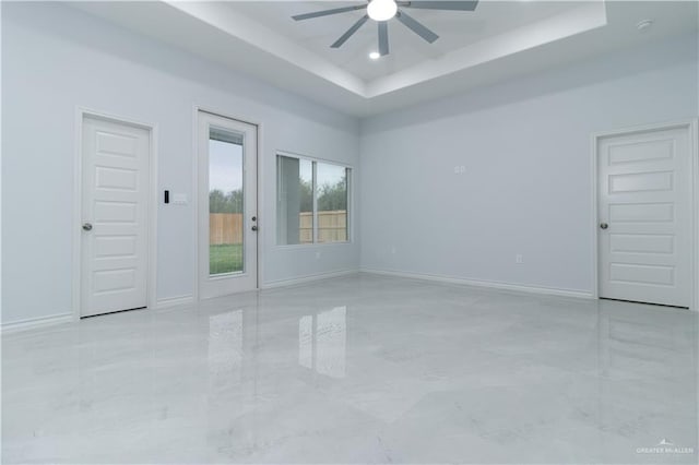 spare room with a raised ceiling and ceiling fan