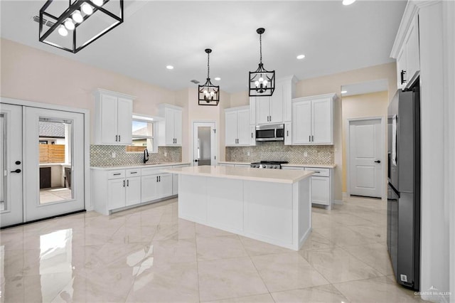 1809 Diplomat Dr, Edinburg, TX 78542 - kitchen featuring a sink, freestanding refrigerator, stainless steel microwave, light countertops, and a chandelier