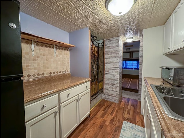 kitchen featuring backsplash, a toaster, dark wood-style floors, an ornate ceiling, and a sink