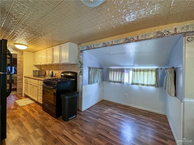 kitchen featuring baseboards, an ornate ceiling, black appliances, and dark wood-style flooring