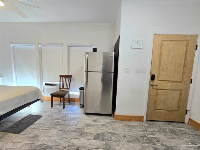 kitchen with ceiling fan, a wall unit AC, and stainless steel refrigerator