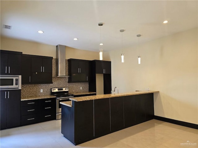 kitchen with wall chimney range hood, sink, appliances with stainless steel finishes, backsplash, and decorative light fixtures