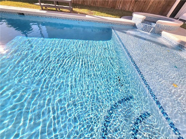 view of swimming pool with a hot tub