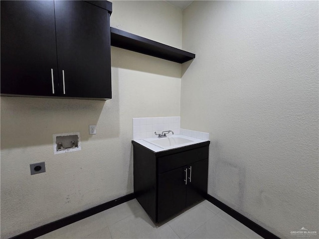 clothes washing area featuring sink, cabinets, washer hookup, light tile patterned flooring, and hookup for an electric dryer