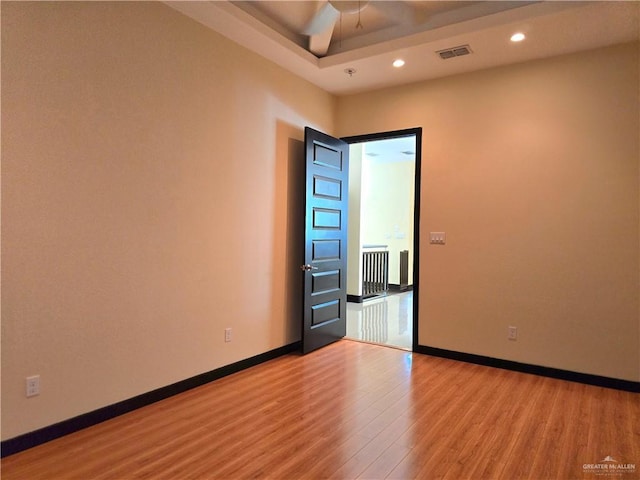 empty room with ceiling fan and light hardwood / wood-style floors