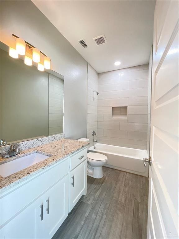2108 Davenport St, Weslaco, TX 78596 - bathroom featuring wood finished floors, toilet, shower / bathtub combination, and vanity