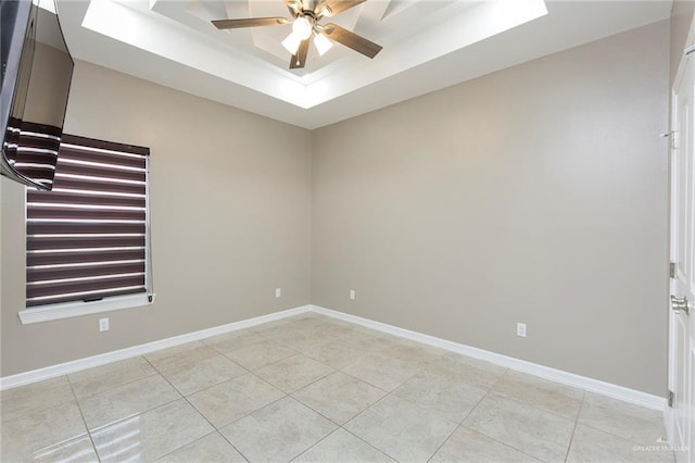 spare room featuring light tile patterned floors, a raised ceiling, and ceiling fan