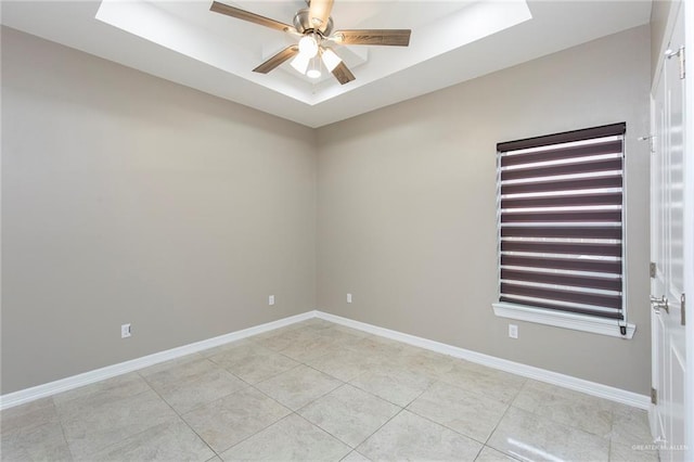 unfurnished room featuring a raised ceiling, light tile patterned flooring, and ceiling fan