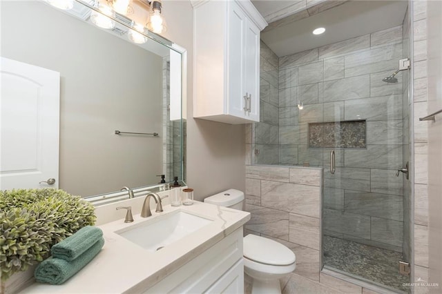 bathroom featuring a shower with door, vanity, and toilet