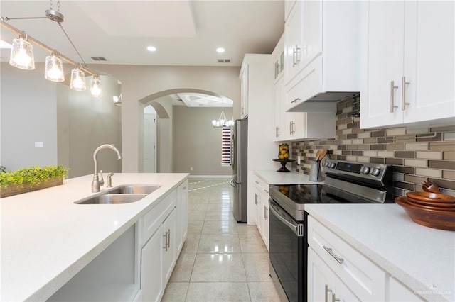 kitchen featuring pendant lighting, sink, white cabinets, backsplash, and stainless steel appliances