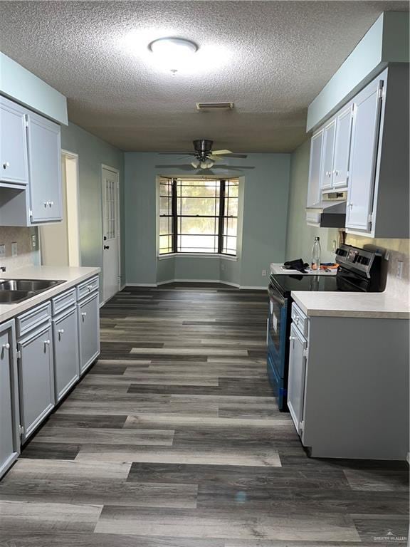 1601 S Oklahoma Ave, Weslaco, TX 78596 - kitchen with electric range oven, ceiling fan, light countertops, dark wood finished floors, and a textured ceiling