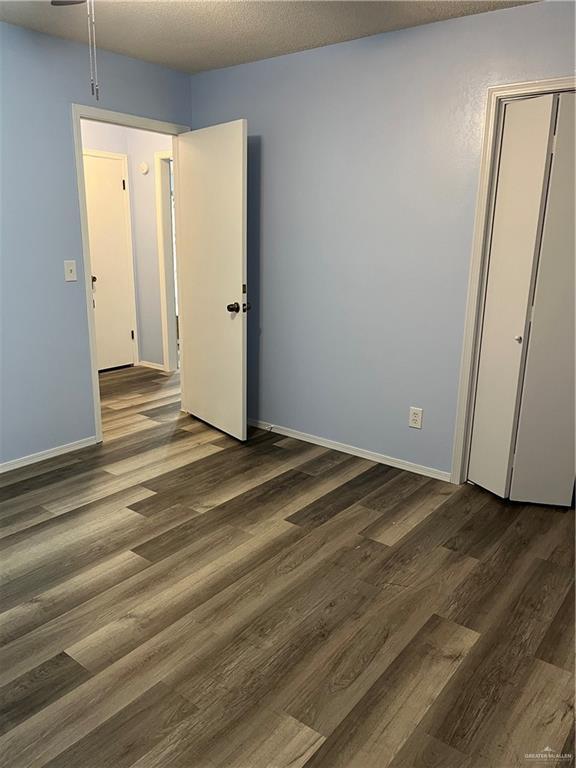 1601 S Oklahoma Ave, Weslaco, TX 78596 - empty room featuring wood finished floors and baseboards