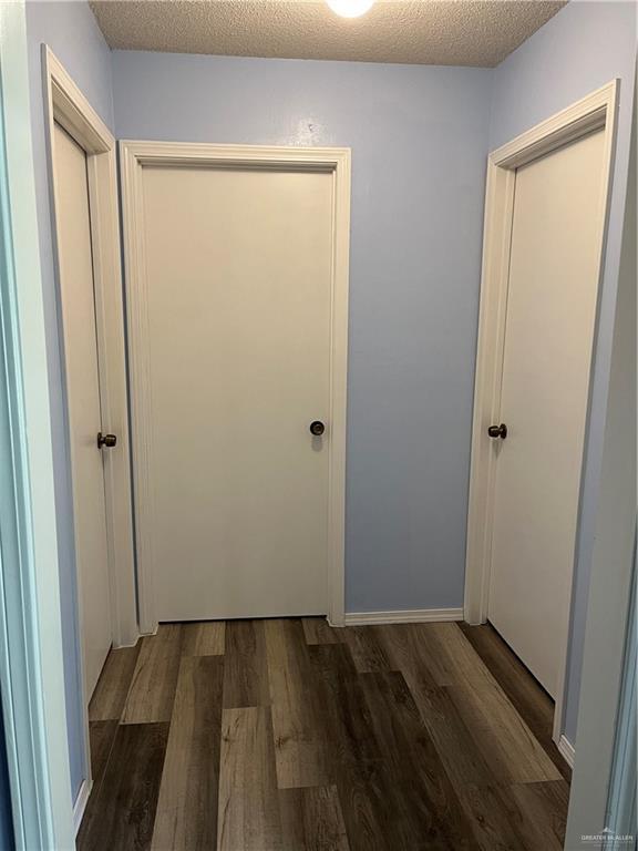1601 S Oklahoma Ave, Weslaco, TX 78596 - hallway featuring wood finished floors and a textured ceiling