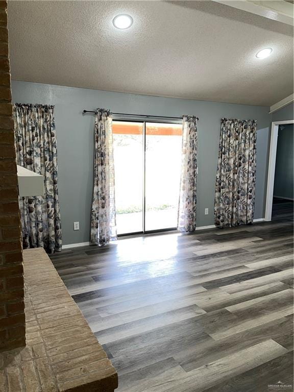 1601 S Oklahoma Ave, Weslaco, TX 78596 - unfurnished living room featuring a textured ceiling, wood finished floors, and recessed lighting