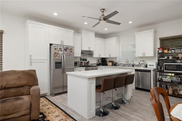 kitchen featuring white cabinetry, a center island, light hardwood / wood-style floors, and appliances with stainless steel finishes