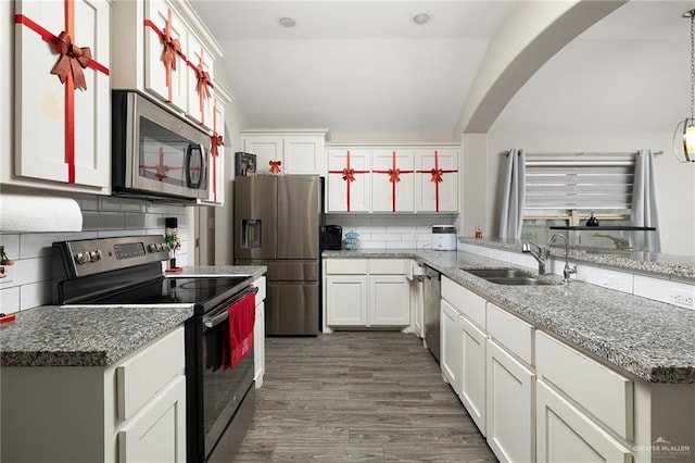 kitchen with dark hardwood / wood-style flooring, stainless steel appliances, sink, white cabinetry, and hanging light fixtures