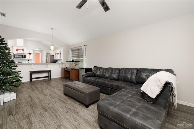 living room featuring hardwood / wood-style flooring, ceiling fan, and vaulted ceiling