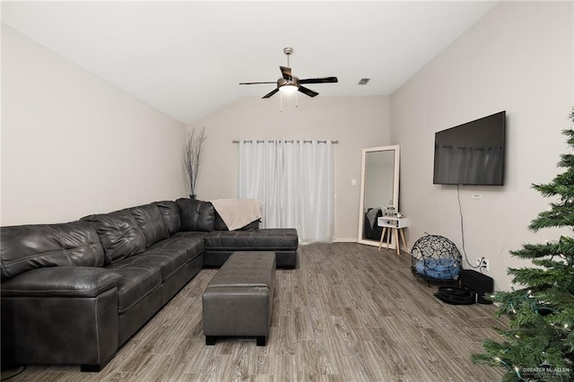 living room featuring hardwood / wood-style flooring, ceiling fan, and vaulted ceiling