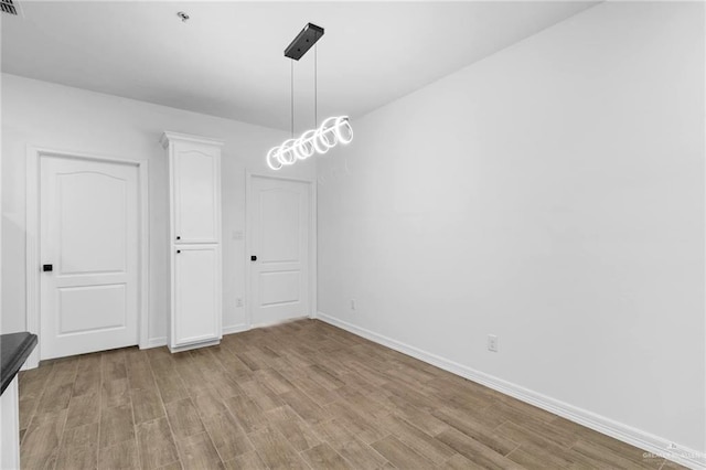 unfurnished dining area featuring light wood-type flooring