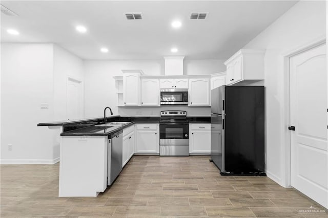 kitchen featuring kitchen peninsula, sink, white cabinets, and appliances with stainless steel finishes