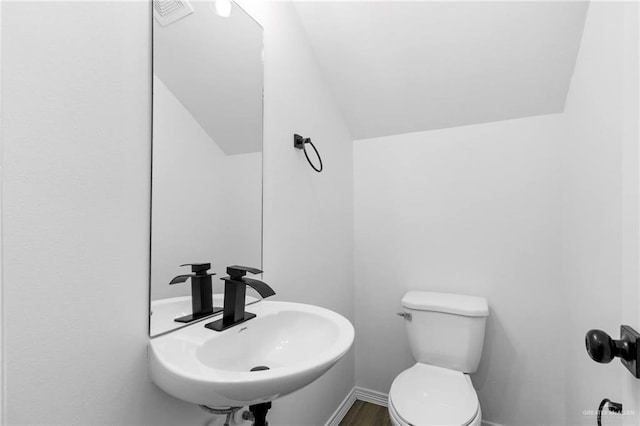 bathroom featuring toilet, wood-type flooring, and sink