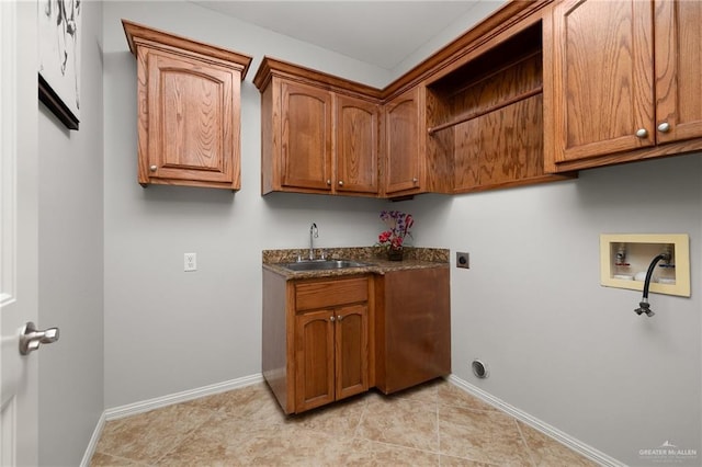 washroom with cabinets, sink, hookup for a washing machine, light tile patterned floors, and hookup for an electric dryer