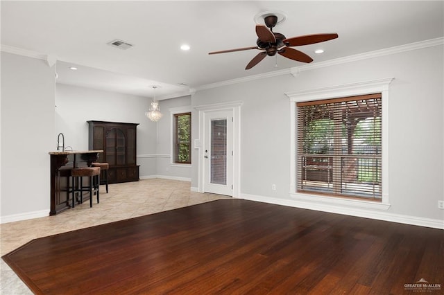 living room with light hardwood / wood-style floors, ceiling fan, and crown molding