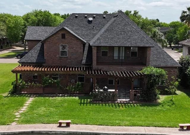 rear view of house with a yard and a balcony