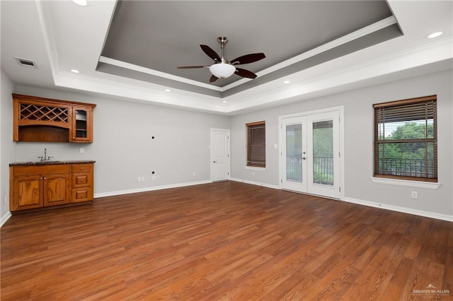 unfurnished living room with french doors, a raised ceiling, and dark wood-type flooring