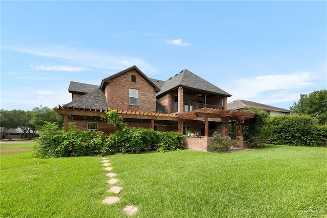 rear view of house featuring a pergola and a yard