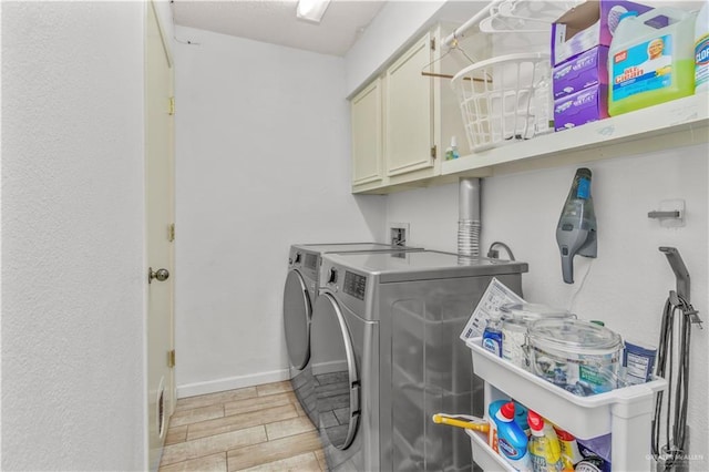 washroom with baseboards, cabinet space, separate washer and dryer, and wood tiled floor