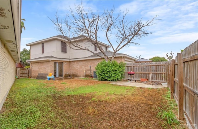 view of yard with central AC, a fenced backyard, and a patio area